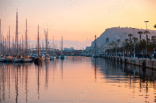 Sunset over the marina in Barcelona Spain with water reflections and view of Mont Juic © Kristjan