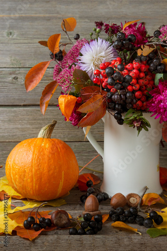 Autumn still life withpumpkin and a bouquet flowers.