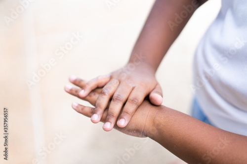 Fototapeta Naklejka Na Ścianę i Meble -  Close up of ameican african kid hands applying alcohol gel at school.Coronavirus prevention medical hand sanitizer gel for hand hygiene coronavirus covid-19 protection.Hand sanitizer alcohol gel.