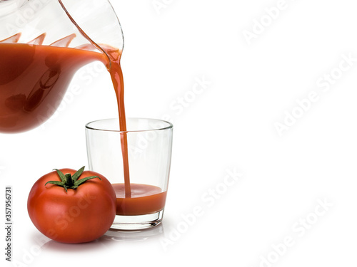 Glass filling by tomato juice photo