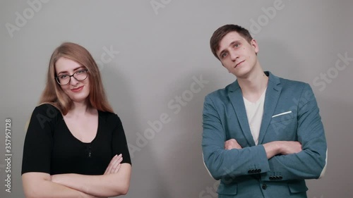 Arms crossed, laughing looking at camera with big grin. Happy face smiling. Positive person. Young attractive couple boyfriend girlfriend two people, dressed black t-shirt, blue jacket, background