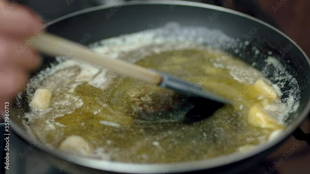 Pouring lemon juice in a frying pan while melting butter. Concept of preparing the salmon sauce. Pouring lemon juice in a frying pan while melting butter. Concept of preparing the salmon sauce.