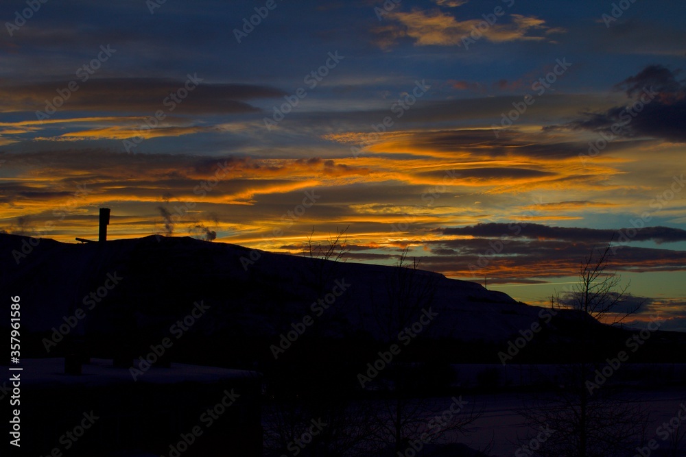 Silhouette of Kiruna Iron ore mine with yellowish brown twilight sky in the background just after sunset