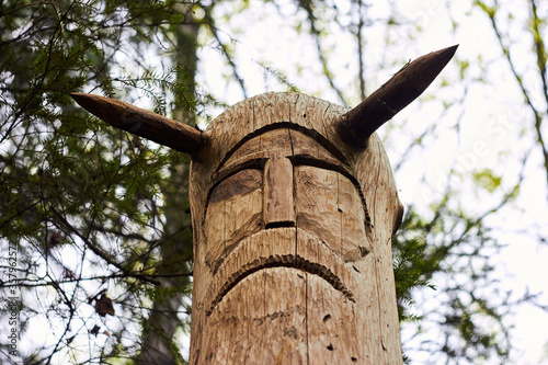 Image of the Slavic deity Veles carved from a tree trunk on a neo-Pagan temple in the forest. Kaluzhskiy region, Russia. Veles - the god of cattle breeding, wealth and wisdom photo