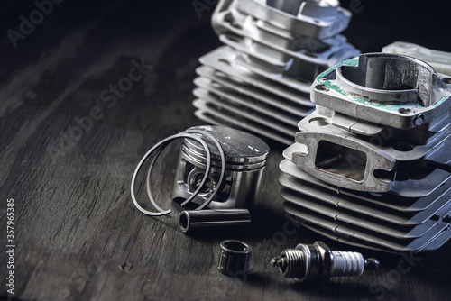 Damaged cylinder. Spark plug. Chainsaw engine parts. Piston, pin, rings. Garden equipment service and repair