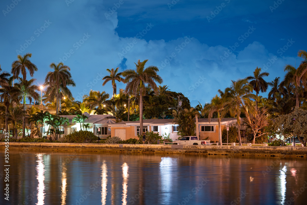 Night photo waterfront houses with palm trees