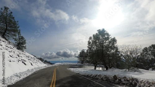 Driving down from the top of Mount Hamilton, on a sunny winter day with fresh snow covering the mountain slopes; South San Francisco Bay Area, California