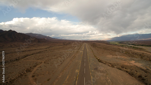 road into the desert. Aerial view of the wide and empty asphalt highway across the mountains. 