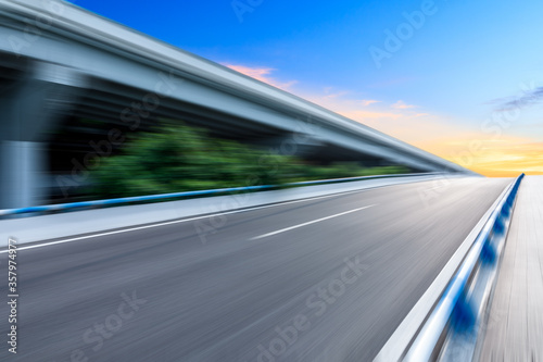 Fast moving asphalt road and bridge background.