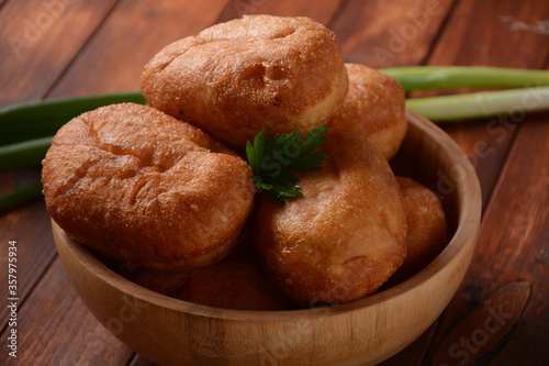 Stuffed Buns (Pirozhki) in wooden bowl on the wooden background.Homemade pasty, Russian stuffed pastry.