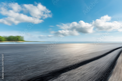 Motion blurred asphalt highway and lake natural landscape.