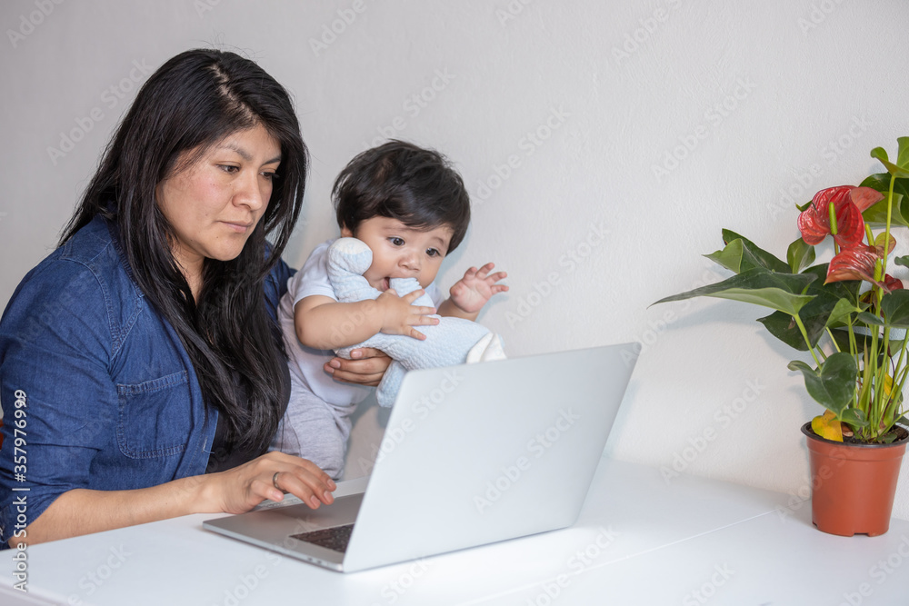 Mexican Mother working from home while her son distracts her and drawing attention Mexican Mother working from home while her son distracts her and drawing attention