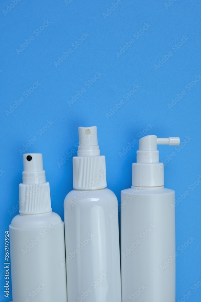.Cosmetic bottles Mockup. White plastic bottles on a light blue background. Beauty and health.Hand disinfector Bottle Set
