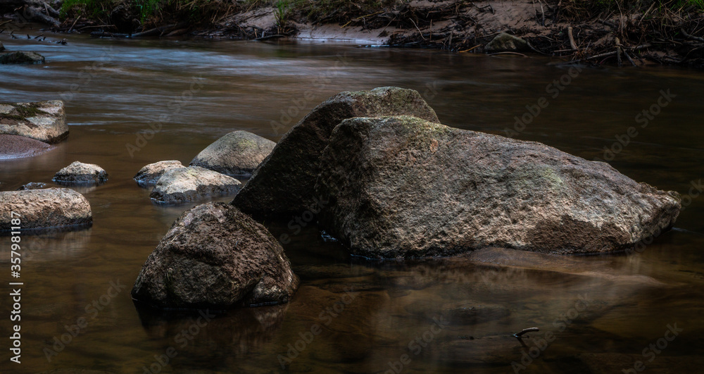 small river in forest with stones at sunset small river in forest with stones at sunset