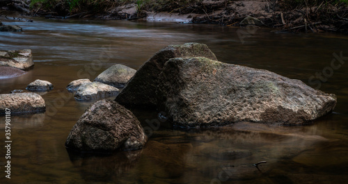 small river in forest with stones at sunset © EriksZ