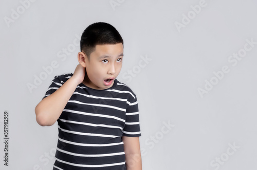 Asian boys studio portrait on gray background with looks shocked