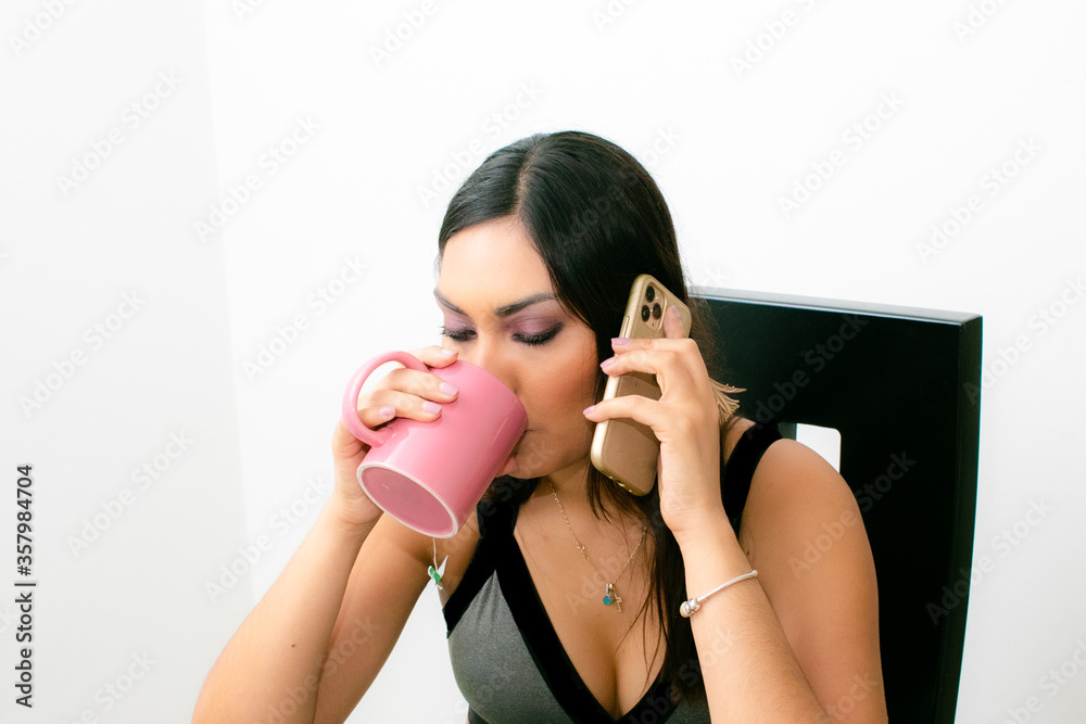 Chica tomando café mientras habla por celular y desayuna Chica tomando café mientras habla por celular y desayuna
