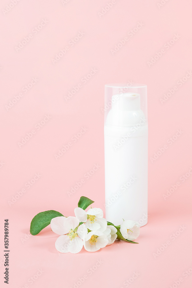 One white blank cosmetic tube bottle and flower, blooming branch on pink background. Natural Organic Spa Cosmetic Beauty Concept. Mockup Front view One white blank cosmetic tube bottle and flower, blooming branch on pink background. Natural Organic Spa Cosmetic Beauty Concept. Mockup Front view