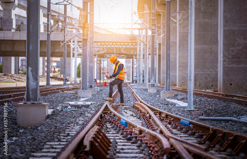 Engineer under inspection and checking construction process railway switch and checking work on railroad station .Engineer wearing safety uniform and safety helmet in work.