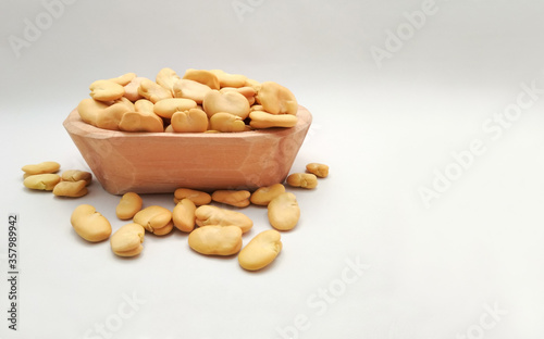 Broad Beans, Also called Fava or Windsor Bean in wooden bowl on white background. copy space