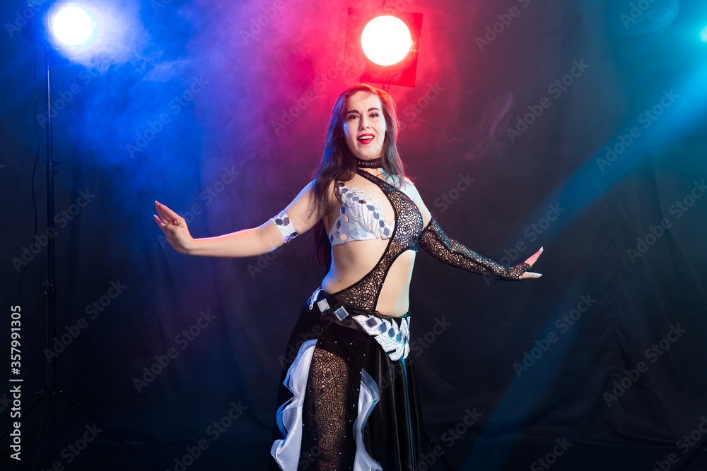 Young woman dancing in Tribal Fusion style. Belly dance on the stage.