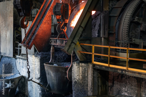 View of the big induction furnace and melting pot in foundry for smelting. The ores of base metals are often sulfides. In recent centuries, reverberatory furnaces have been used to keep the charge. photo