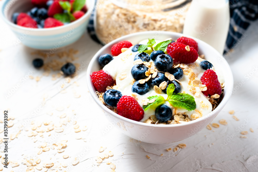Breakfast, oatmeal with blueberry and raspberry on white bowl in the morning. Breakfast, oatmeal with blueberry and raspberry on white bowl in the morning.