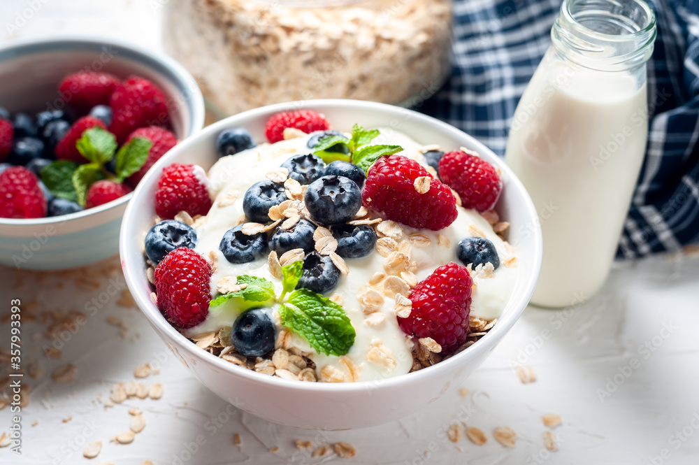 Breakfast, oatmeal with blueberry and raspberry on white bowl in the morning. Breakfast, oatmeal with blueberry and raspberry on white bowl in the morning.