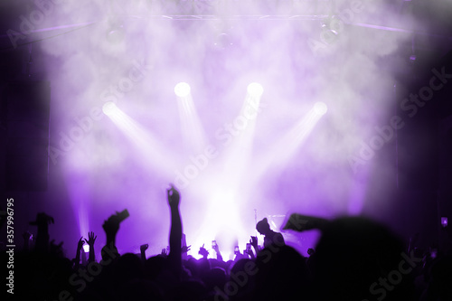 silhouette of an emotional crowd at a music festival in front of a spotlight stage. shoot a concert on a smartphone. concert banner or poster. Blur. Selective focus © Евгений Вдовин