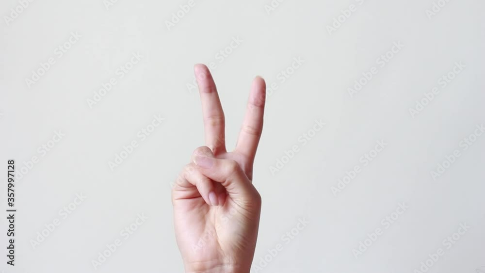 Female one hand holding two fingers up in sign language.two fingers up and showing peace or victory symbol or letter V. Female one hand holding two fingers up in sign language.two fingers up and showing peace or victory symbol or letter V.