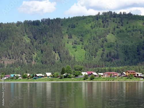 Russian Village on the river Bank near the mountain