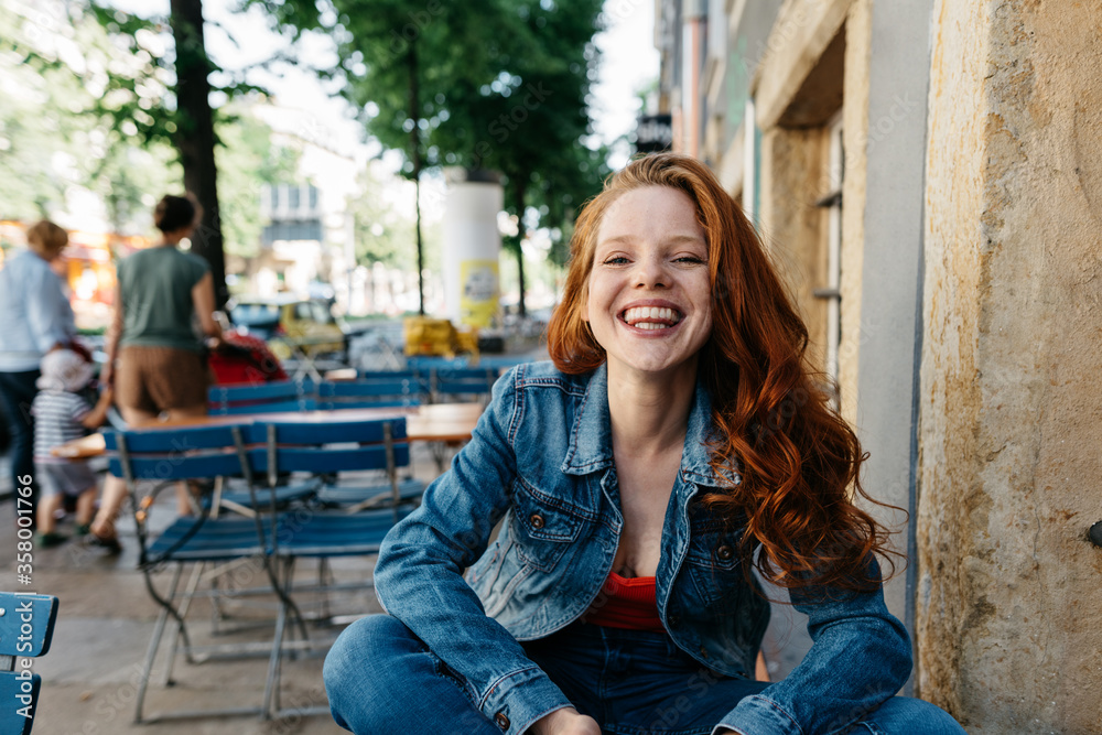 Cute young redhead woman with happy grin