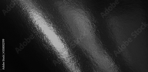 Black foil gradient texture background with uneven surface