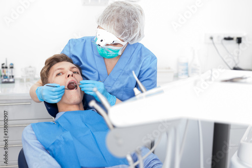 Young man on dental checkup in modern dentist office