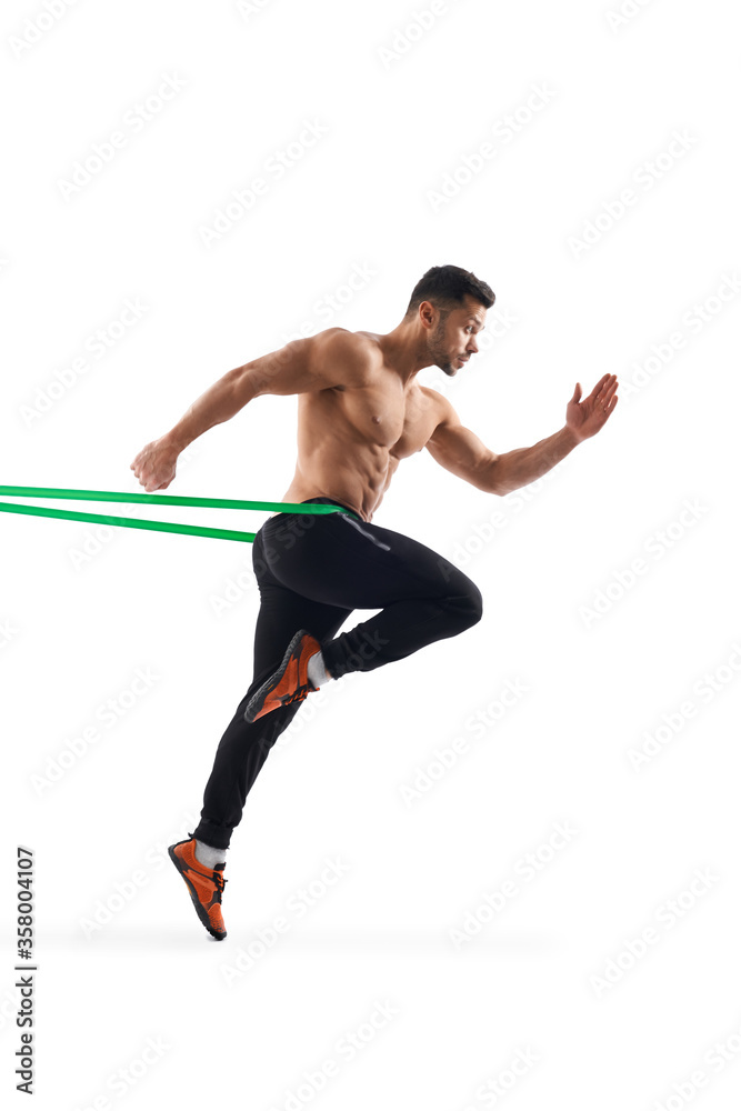Shirtless man running in place using resistance band. Shirtless man running in place using resistance band.