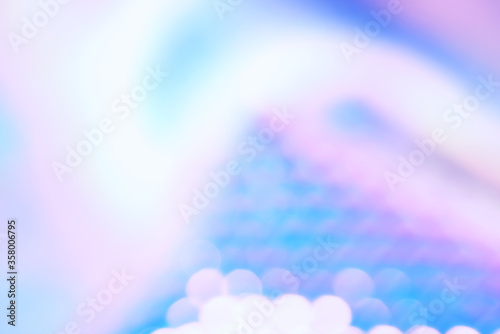 Holographic color foil with shiny reflections and bokeh light effect. Abstract blurred holographic foil background with trendy ultra violet light pastel colors. photo