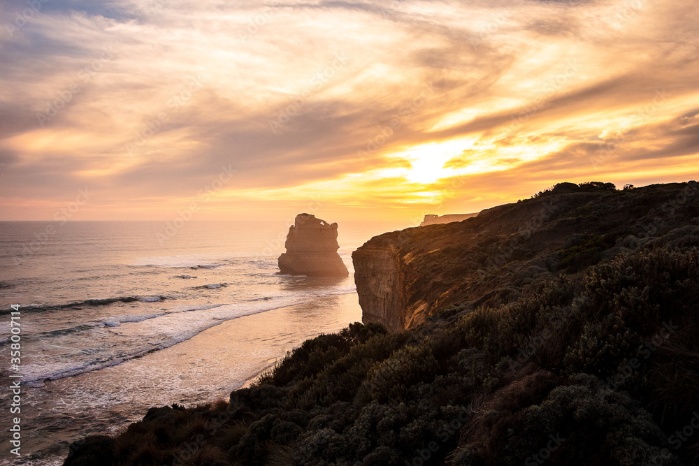 Gibson Steps at Sunset, Melbourne, Victoria, Australia. Colorful sky and clouds on a pristine beach with cliffs, vegetation and ocean composing the landscape.