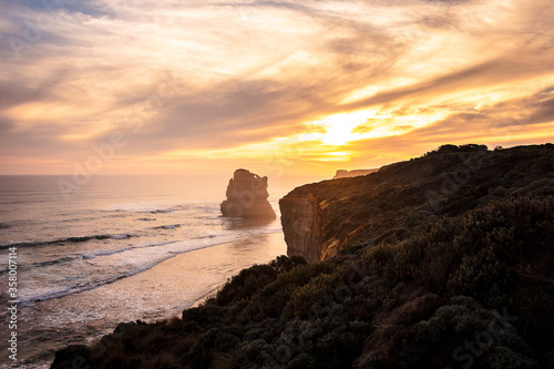 Gibson Steps at Sunset, Melbourne, Victoria, Australia. Colorful sky and clouds on a pristine beach with cliffs, vegetation and ocean composing the landscape.