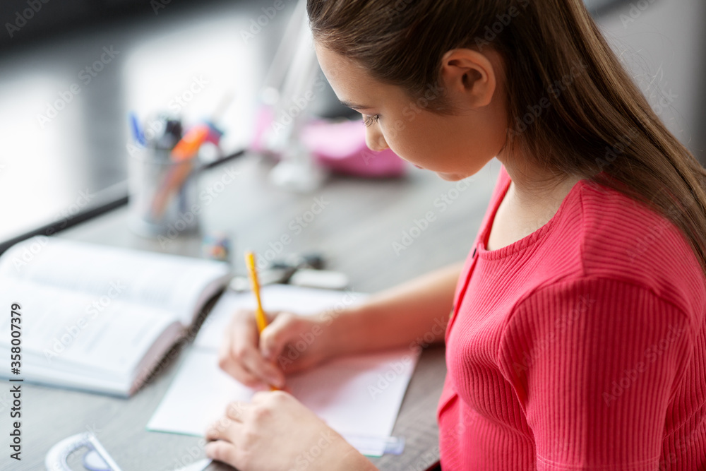 children, education and learning concept - student teenage girl with ruler drawing line in notebook at home children, education and learning concept - student teenage girl with ruler drawing line in notebook at home