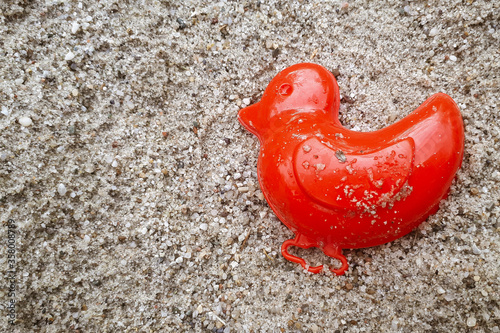 Sand toy on beach. Closeup pastic colorful toy for child. SToy items on the sand. childhood concept. photo