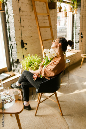 young stylish girl girl drinks coffee. Girl blogger with a cup of coffee in cafe with magazine 