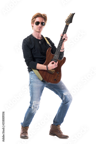 Passionate tough rock guitar player playing electric guitar with confidence. Full body length isolated on white background. 