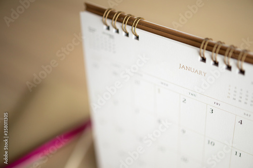 calendar page close up on wood table background with pen and notebook business planning appointment meeting concept