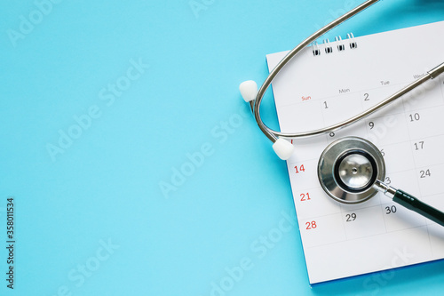 Foto Stethoscope with calendar page date on blue background doctor appointment medica