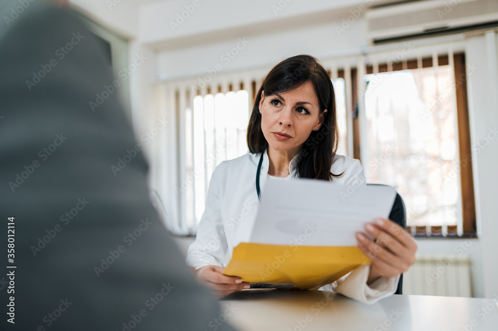Portrait of a serious doctor looking at test results of a patient. Portrait of a serious doctor looking at test results of a patient.