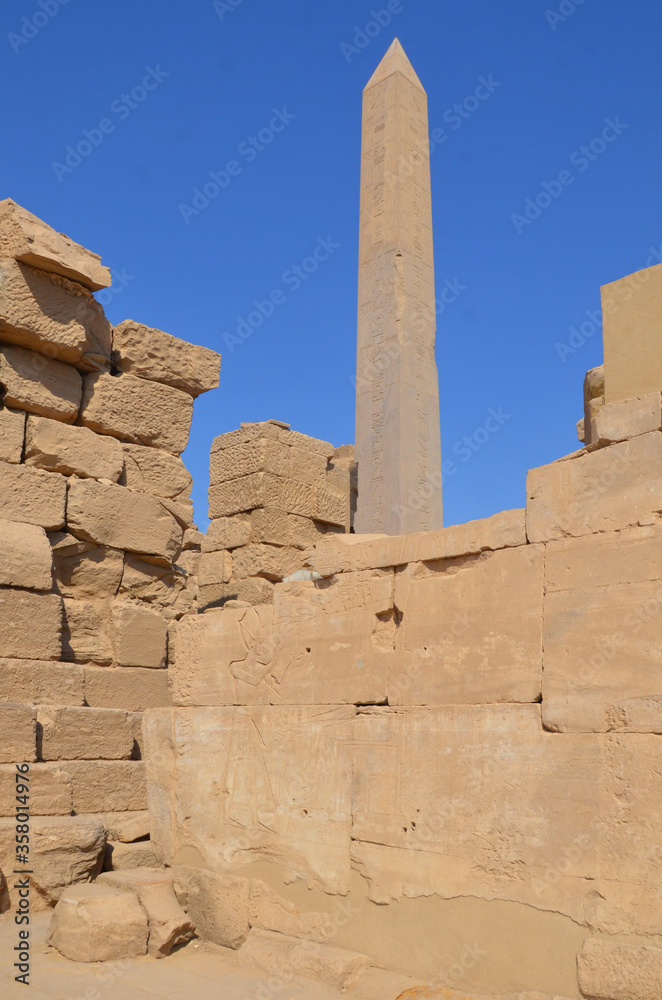Travel tour group wanders through Karnak Temple. Beautiful Egyptian landmark with hieroglyphics, decayed temples, obelisks, towers, and other buildings. Luxor, Egypt