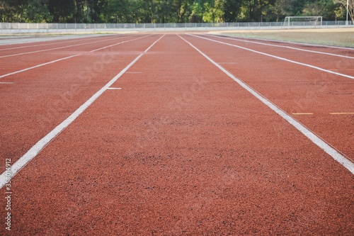 Empty red running track in stadium. Sport and exercise concept