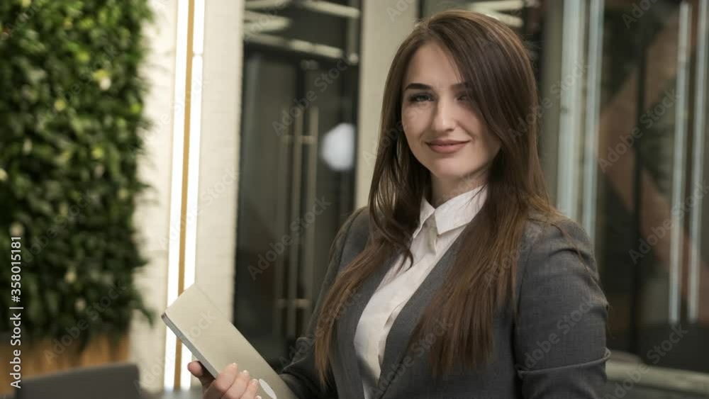 Portrait of a young business woman smiling with a laptop in the hands Portrait of a young business woman smiling with a laptop in the hands
