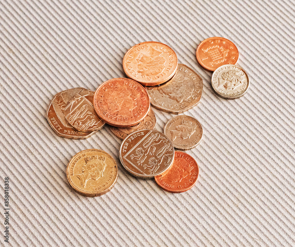 Many different coins from different countries from the black wallet are scattered around the table: dollars, pounds, rubles, pennies, cents, yuan. Saving money, losing finance, earning. Many different coins from different countries from the black wallet are scattered around the table: dollars, pounds, rubles, pennies, cents, yuan. Saving money, losing finance, earning.