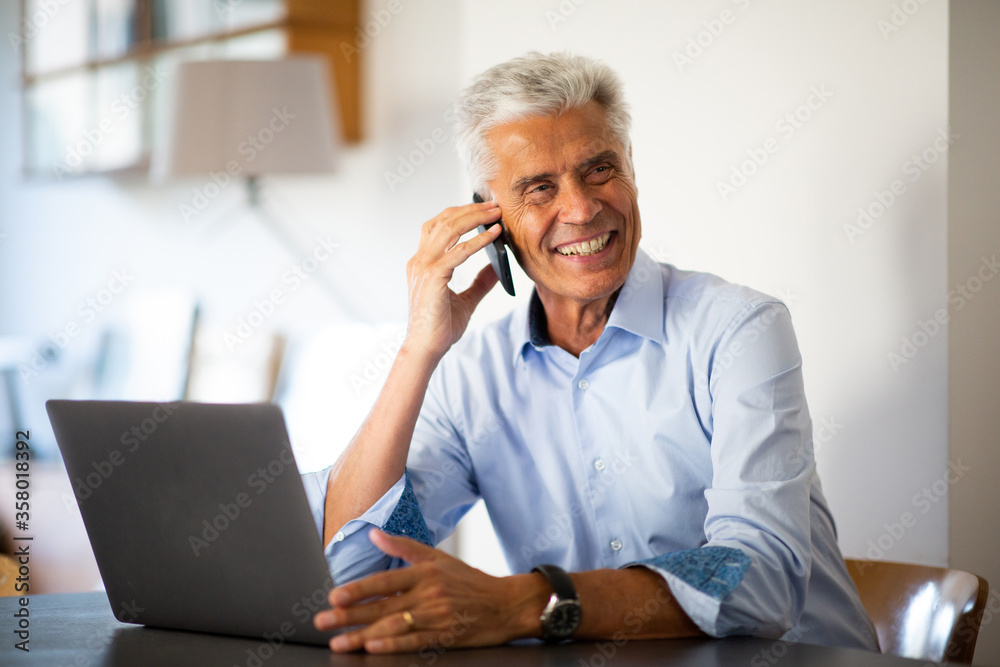 businessman sitting at work talking with mobile phone businessman sitting at work talking with mobile phone
